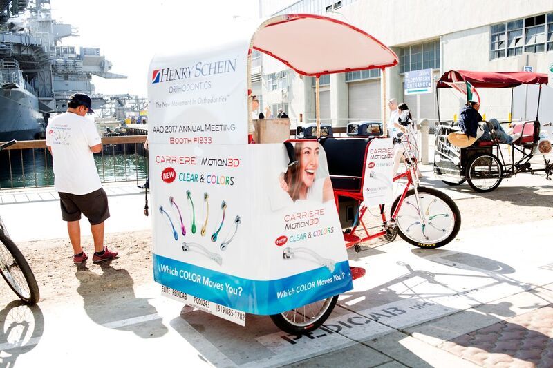 A pedicab parked on the waterfront near the USS Midway